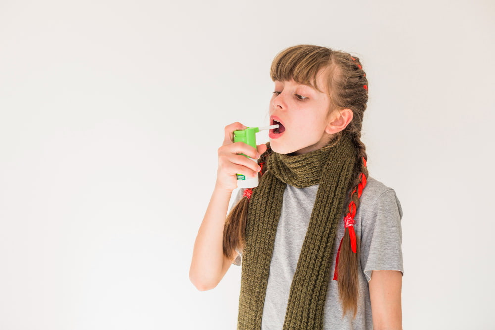 A girl experiencing discomfort from dry mouth, using a mint spray for relief