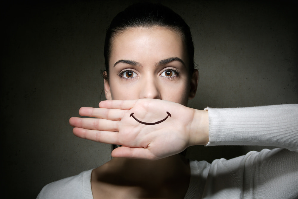 A woman hiding her smile with her hands,