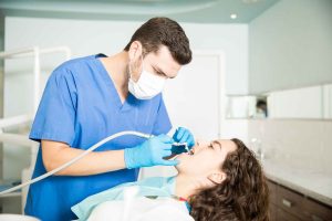 Young woman receiving dental treatment from male dentist in a modern clinic in Oklahoma City, OK