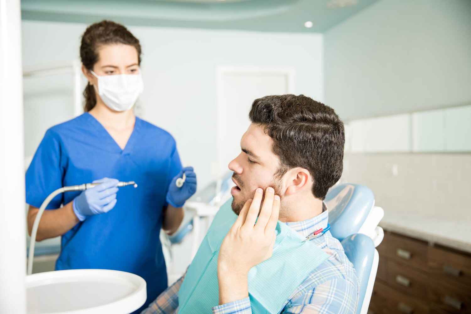 Female patient experiencing toothache during dental consultation in a clinic setting