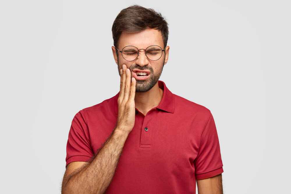 Man experiencing severe tooth pain due to wisdom teeth